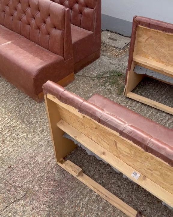 Upholstered bar banquette seating removed from a venue and standing outside on the pavement