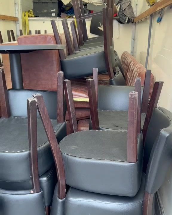 Restaurant chairs and pedestal tables stacked and loaded inside the van